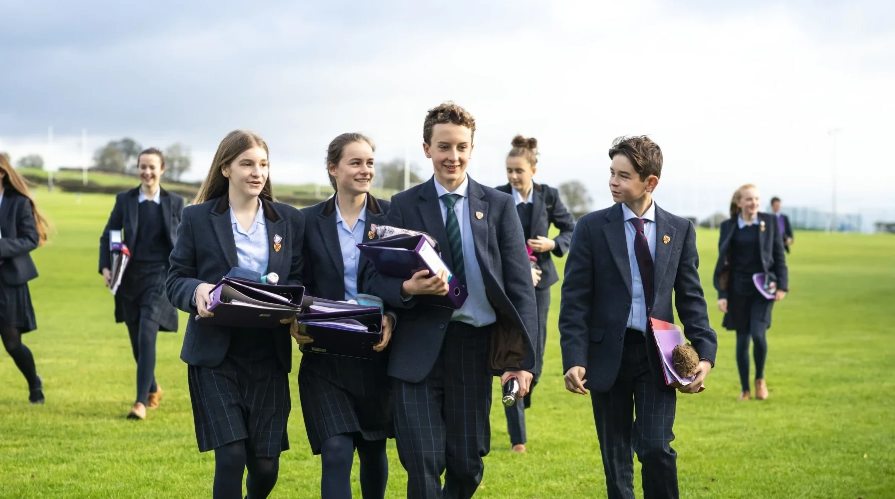 Barnard Castle School senior pupils walking with folders in their hands.