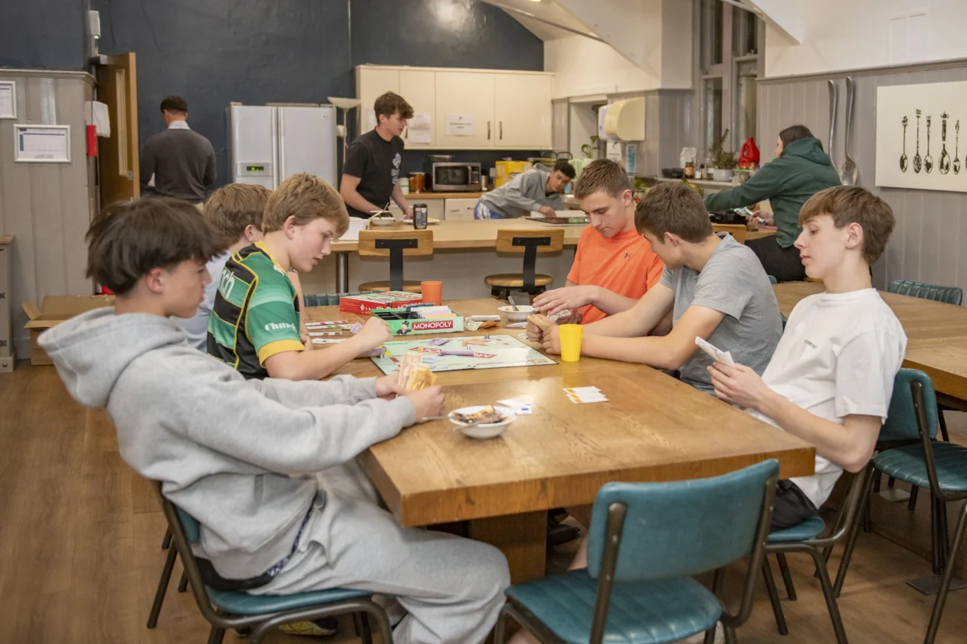 Barnard Castle School pupils in the dorm kitchen together playing board games.