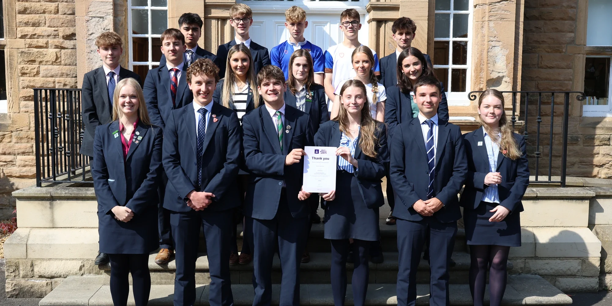 Students stood outside school celebrating completion of Duke of Edinburgh Award.
