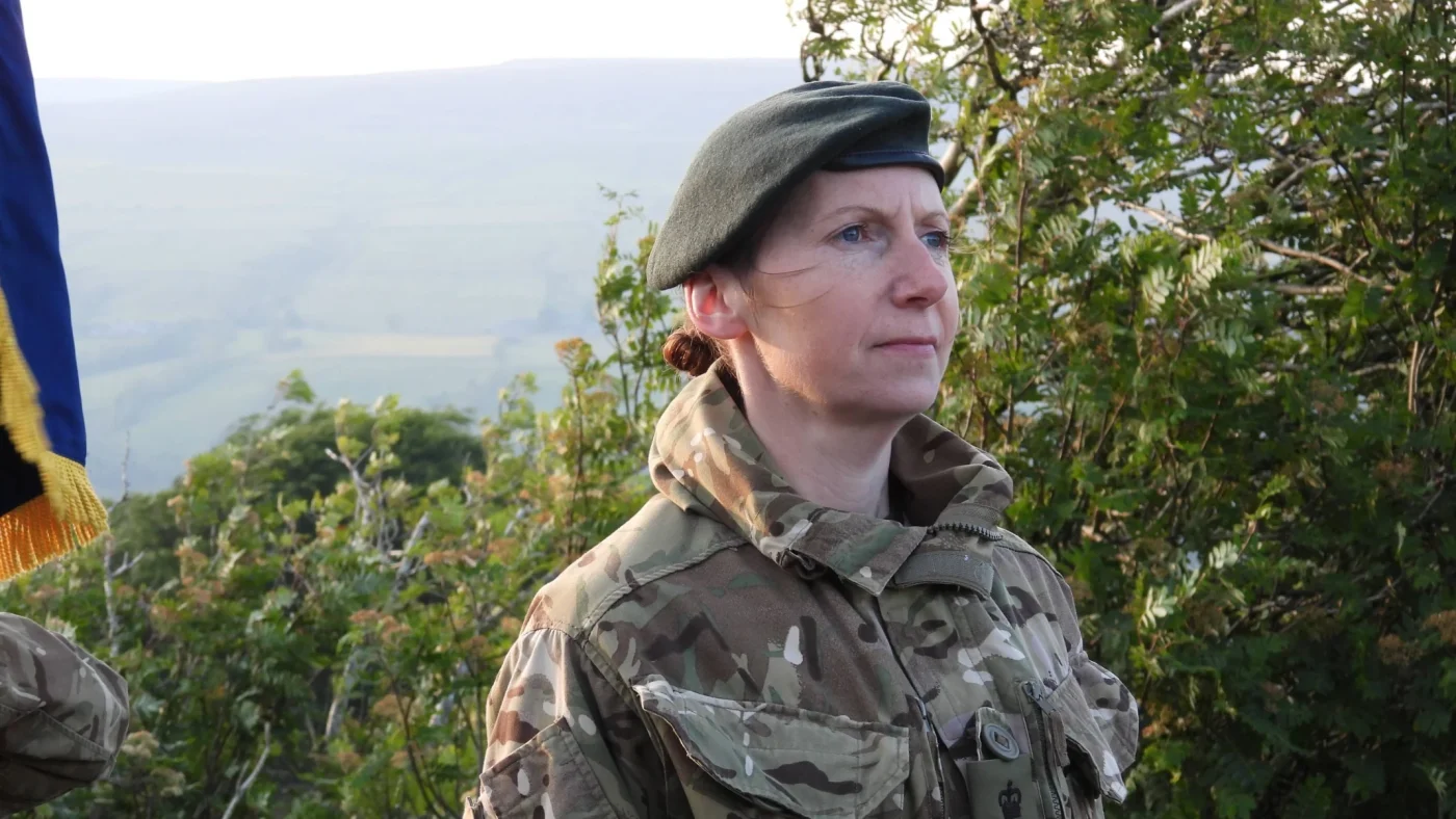 A woman in military uniform in rural England.